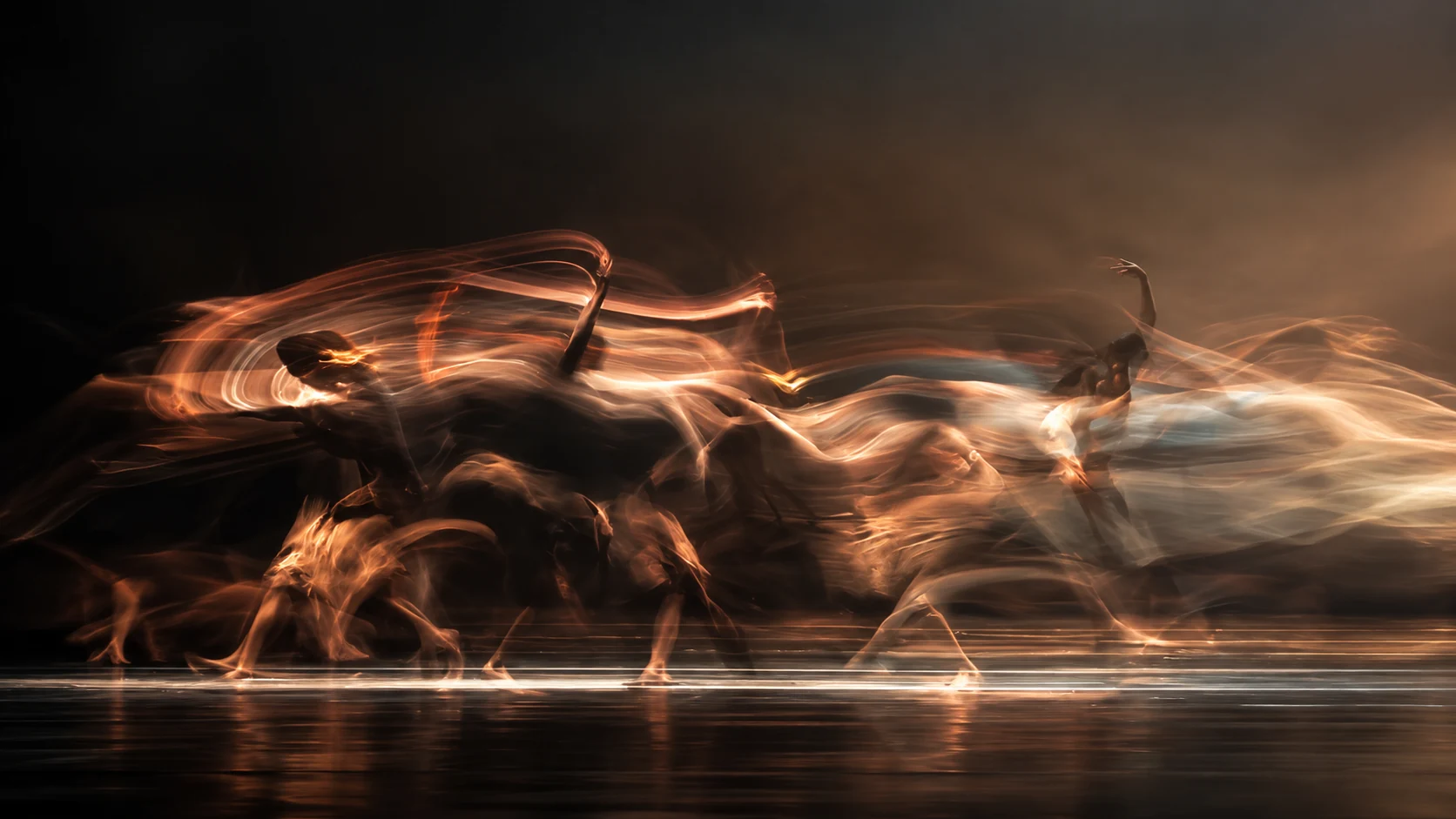 Professional dancers in an atmospheric ballroom under theatrical lighting