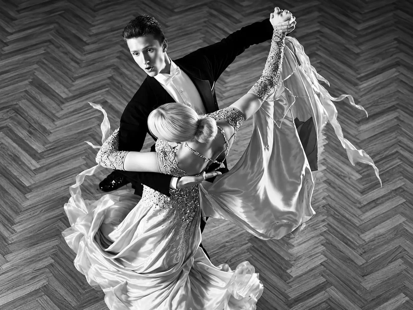 Ballroom couple performing a sweeping dance in a grand venue