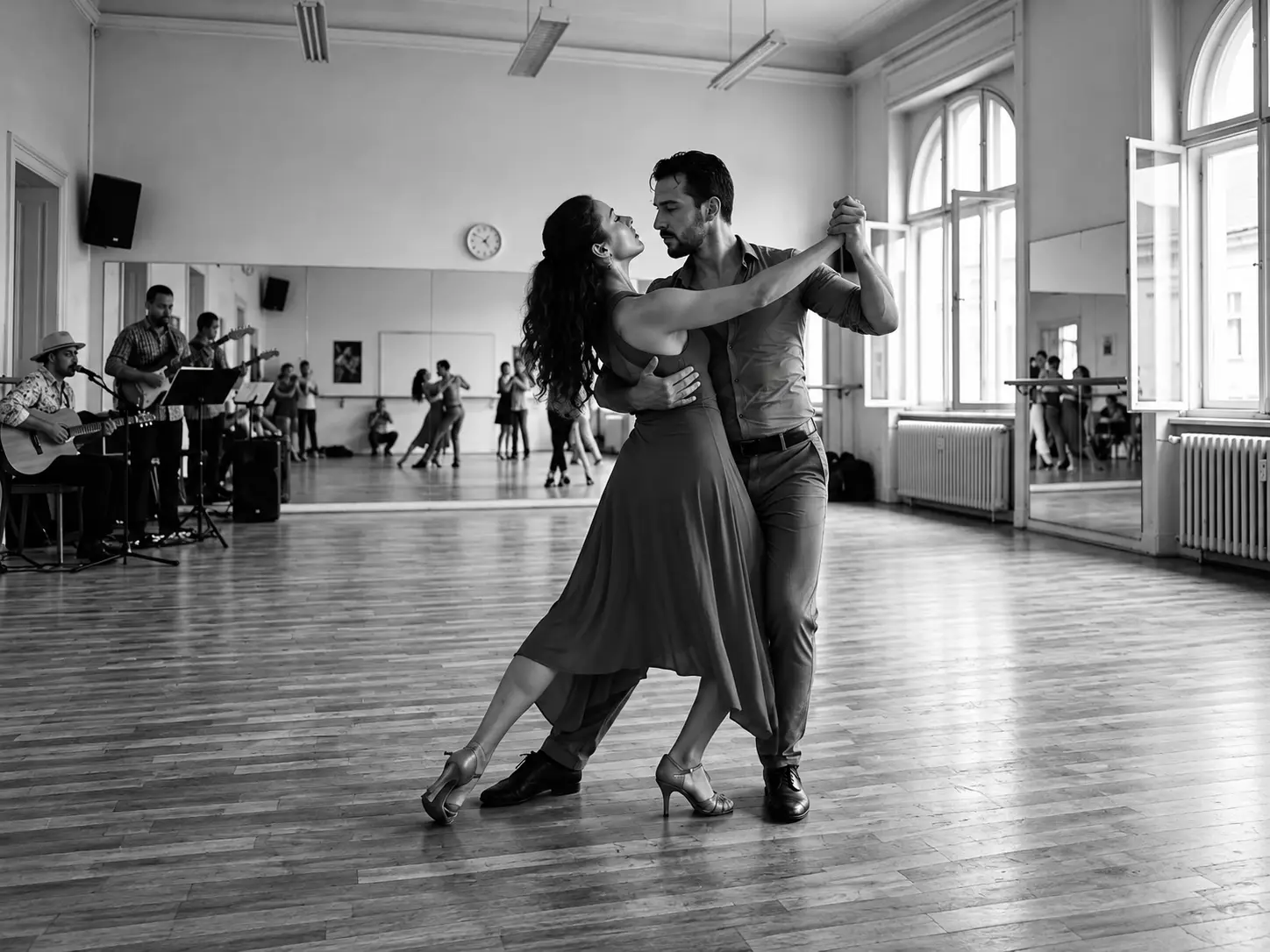 Latin dancers on stage in dramatic warm lighting